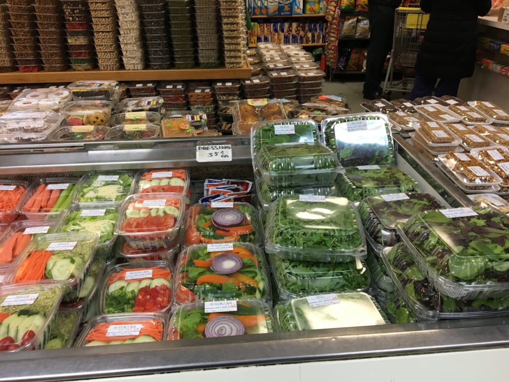 Pre-made salads in the foreground and a ton of dried fruits and nuts in the background.